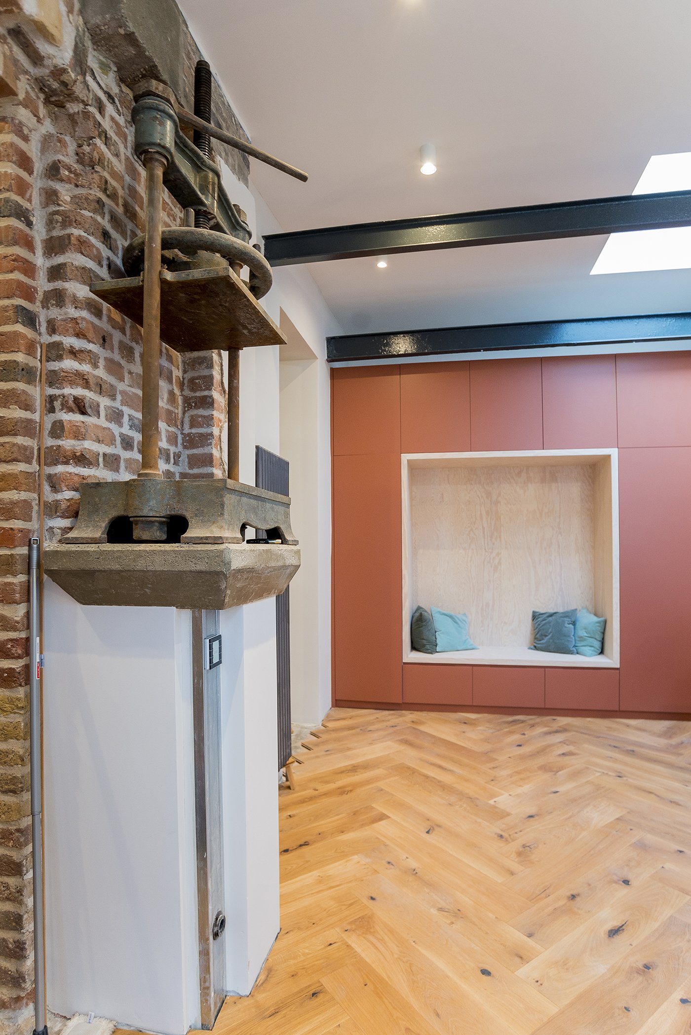 Historische Buchpresse aus Gusseisen an der Backsteinwand